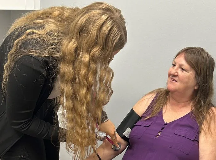 Care team member checking a patient's blood pressure during a visit